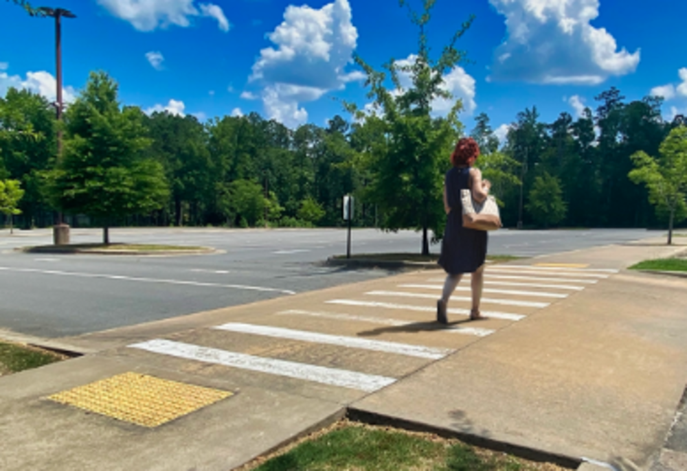 Pedestrian walking on raised crosswalk.
